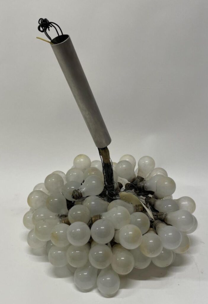 – (V4-VR3) Lustre en métal chromé à accumulation d'ampoules reliées par des fils de fer. (Accidents et manques.) Haut. : 80 cm ; Diam. : 50 cm.